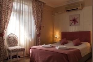 a bedroom with a bed and a chair and a window at Dalyan Terrace Hotel in Dalyan