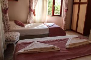 two beds in a room with a window at Dalyan Terrace Hotel in Dalyan