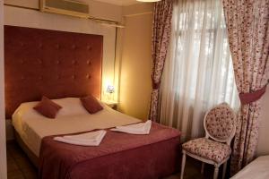 a bedroom with a bed and a chair and a window at Dalyan Terrace Hotel in Dalyan
