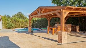 un pabellón de madera con mesa y piscina en Casa Rural Aguasal El Bosque by Ruralidays, en El Bosque