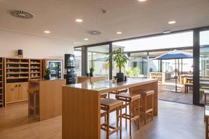 uma cozinha em plano aberto com um bar com bancos em BFRESH Hotel - Padel, Pool & Fitness - Adults Only no Porto