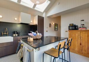 a kitchen with a counter and some chairs in it at Iluka in Herne Bay