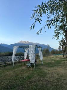 a picnic table with a canopy in a field at The Posh Camps in Pahalgām
