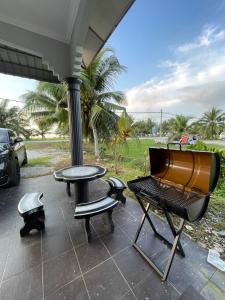 a grill and a table and chairs on a patio at ARY&ZZ Homestay for islam guests in Tanjung Karang
