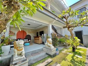 una casa con dos estatuas blancas en un patio en CG Guesthouse Canggu en Canggu