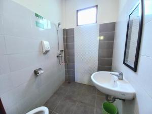 La salle de bains est pourvue d'un lavabo et de toilettes. dans l'établissement Homestay Jogja dekat Malioboro by Simply Homy, à Yogyakarta