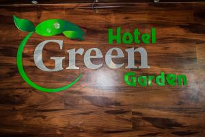 a sign for a hotel green garden on a wooden wall at Hotel Green Garden in Trincomalee