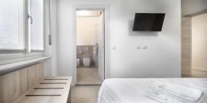 Habitación blanca con cama y TV en b&b Amaca, en Pavia