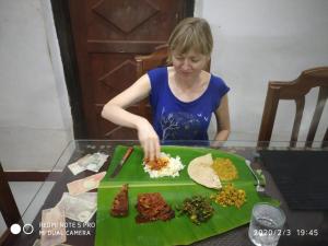 a woman preparing food on top of a table at VALENTINE'S RICE BOWL HOME STAY in Alleppey