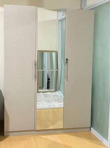 um grande armário branco com um espelho num quarto em Avant at the Fort BGC Corner Unit with Scenic View em Manilla