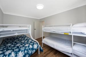 1 dormitorio con 2 literas con sábanas azules y blancas en Moore Family Time en Guilderton