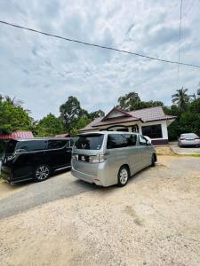 two cars parked in front of a house at Rania Riverview Guesthouse in Kuala Berang