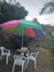 une table et deux chaises sous un parapluie coloré dans l'établissement Pedasito de cielo, à Copacabana