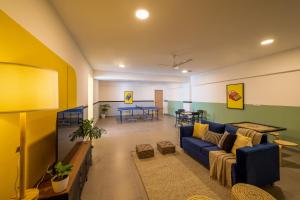 a living room with a blue couch and a table at Olive JP Nagar - by Embassy Group in Bangalore