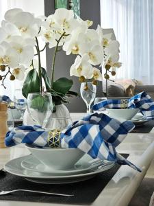 uma mesa com pratos e vasos com flores brancas em Luxury Botanica Apartment 121 em Dubai
