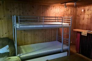 two bunk beds in a room with a wooden wall at Rustikales Hexenhäuschen in Stöde