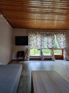 una sala de estar con una gran ventana con cortinas en Rustikales Hexenhäuschen, en Stöde