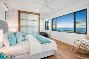 a bedroom with a bed and a large window at Relax & Daydream at 2 Elementa in Airlie Beach