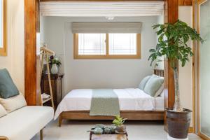 um quarto com uma cama e um vaso de plantas em Memory Stay Seoul Jongro Hanok em Seul