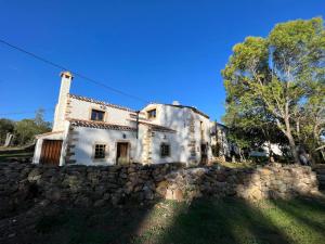 una vieja pared de piedra frente a un edificio en Villa El Molino Blanco, en Molinos de Razón