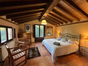 ein Schlafzimmer mit einem großen Bett und Holzdecken in der Unterkunft Villa El Molino Blanco in Molinos de Razón