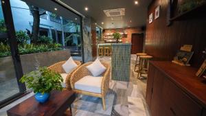 a living room with a chair and a table at CHiEM HoiAn - The Beachside Boutique Hotel & Villa in Hoi An