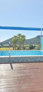 a bench sitting on a boardwalk next to a swimming pool at Primula Hotel - Formerly Sanbangsan Hotel in Seogwipo