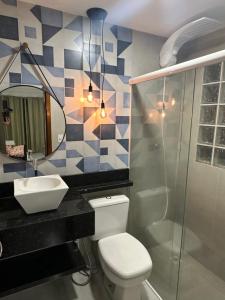 uma casa de banho com um WC, um lavatório e um espelho. em APARTAMENTO SANTORINI 30m DO MAR em Balneário Camboriú