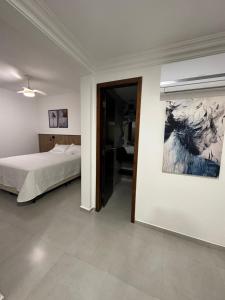 um quarto com uma cama e um quadro na parede em APARTAMENTO SANTORINI 30m DO MAR em Balneário Camboriú