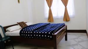 um quarto com uma cama com um cobertor azul em Yashav Homestay em Shillong
