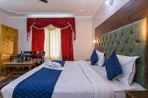a bedroom with a large bed with a red curtain at FabHotel The Moon in Manāli