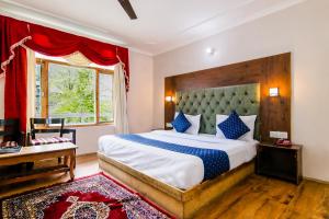 a bedroom with a large bed and a window at FabHotel The Moon in Manāli