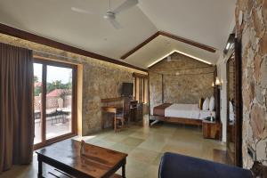 a bedroom with a bed and a table in a room at Vikrama Sarovar Portico Pavagadh in Hālol
