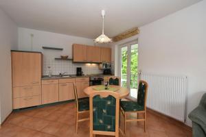 a kitchen with a table and chairs in a room at Ferienwohnung-6-15 in Baabe