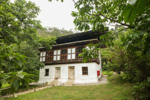 an old house in the middle of a forest at Pemako Punakha in Punākha