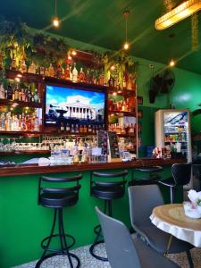 a green bar with chairs and a tv on the wall at Elephant Room in Patong Beach