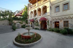 a building with a fountain in the middle of a courtyard at Luxury Cratus Stone Palace in Göreme