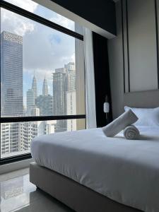 a bed in a room with a view of a city at Axon Residence at Pavilion KLCC KL Tower view by KIMIRO in Kuala Lumpur