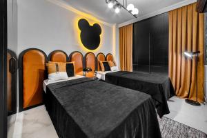シレにあるiBO-APART Luxus Apartmentのベッド2台が備わる客室で、壁にリンゴの看板が付いています。