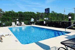 a swimming pool with chairs and a sign on a fence at Western Motel, Thomasville in Thomasville +20 photos