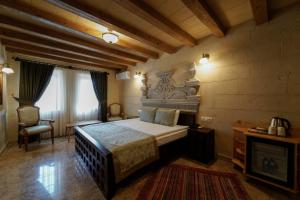 a bedroom with a bed and a chair in a room at Luxury Cratus Stone Palace in Goreme