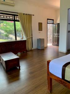 a bedroom with a bed and a wooden floor at Pondok Senaru Cottages in Senaru