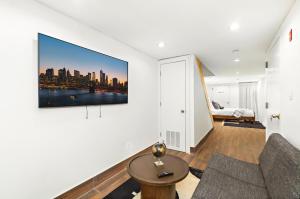 a living room with a couch and a tv on a wall at Luxurious 4 BR Townhouse in New York