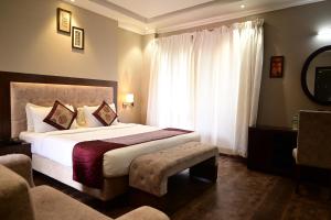 a hotel room with a large bed and a window at De Alturas Resort in Candolim