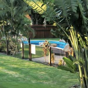 a fence in a yard with a swimming pool at Townsville Eco Resort 