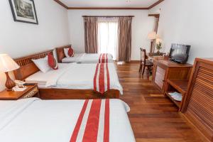 Habitación de hotel con 2 camas y escritorio en Cheathata CTA Hotel Siem Reap, en Siem Reap