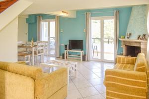 un salon avec deux canapés et une cheminée dans l'établissement Ktima Holiday House, à Skiathos Chora