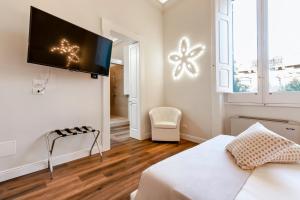 a bedroom with a bed and a flat screen tv on a wall at Vittoria Luxury House in Lecce