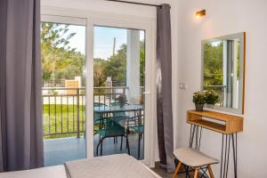 Cette chambre dispose d'une porte coulissante en verre avec une table et des chaises. dans l'établissement Ktima Holiday House, à Skiathos Chora