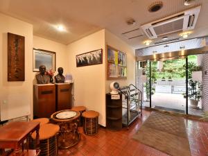 Habitación con 2 estatuas, mesa y taburetes en Hotel Kangetsuso, en Tokio